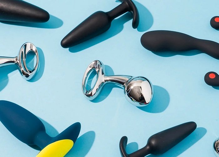 Several real butt plug styles with flared bases arranged for beginner size comparison.