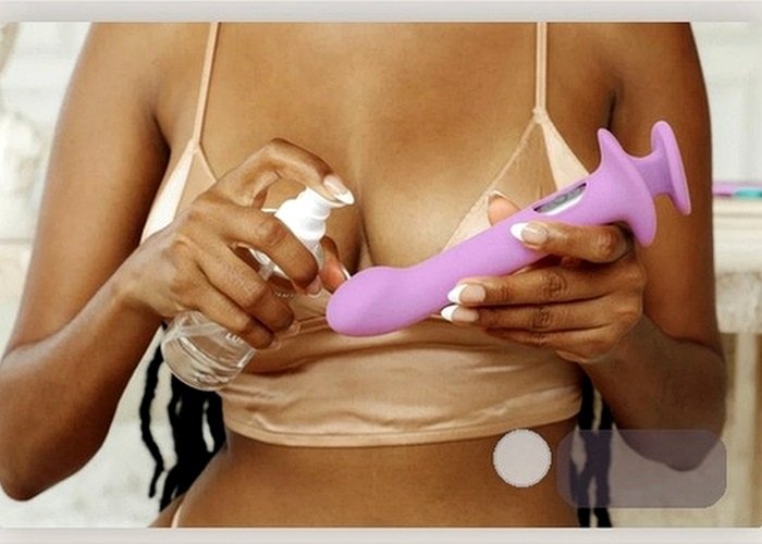 A vibrator and soft towel arranged beside bedding to compare modes and comfort before use.