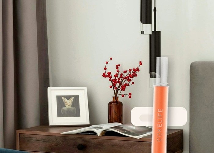 A wand-style vibrator on a towel beside mild soap and a cloth for motor-safe cleaning.