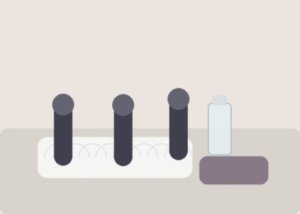 A rechargeable vibrator, cable, and cloth arranged on a bedside table for a charging-check routine.