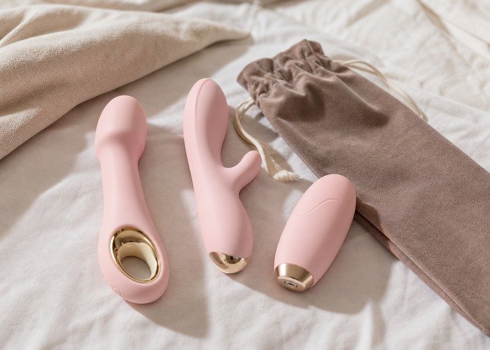 A cleaned set of compact vibrators, pouch, towel, and lubricant arranged to connect shape choice with cleanup and storage.