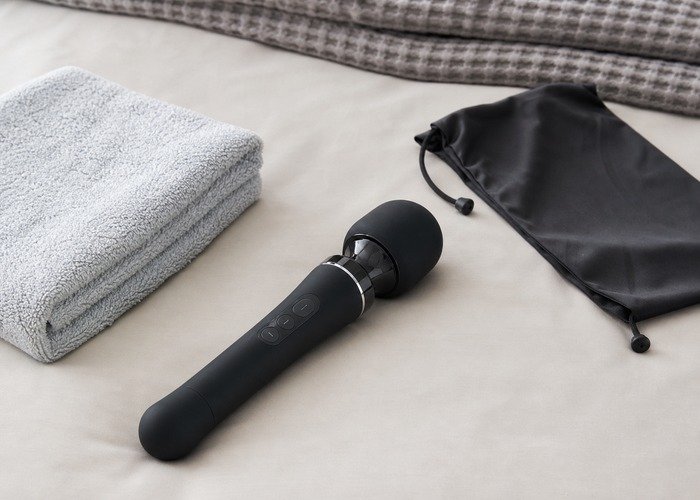 A cleaned rabbit vibrator, wand toy, suction toy, and pouch arranged to connect sensation choice with real cleanup effort.